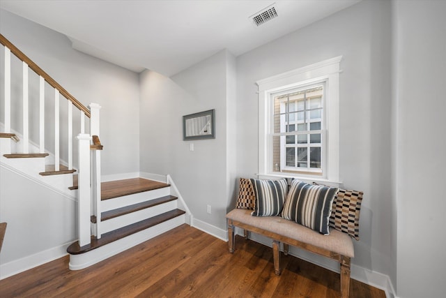 stairs with wood finished floors, visible vents, and baseboards