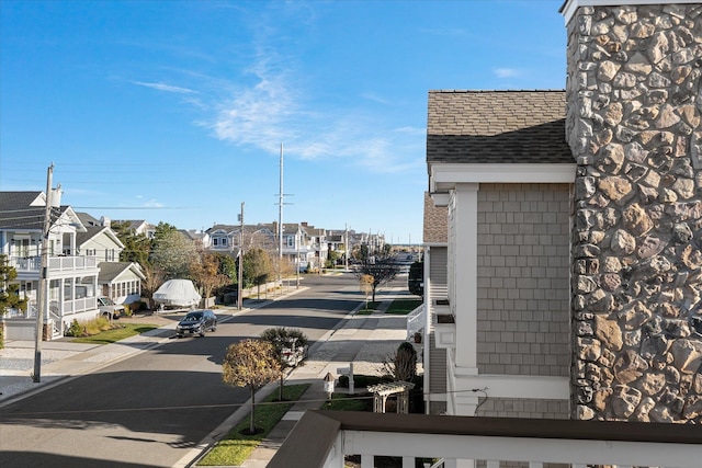 view of street with street lights, curbs, sidewalks, and a residential view