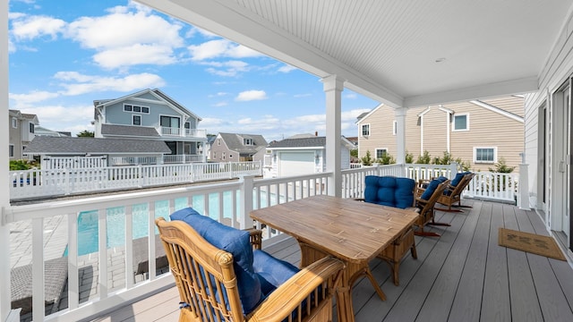 wooden deck with a fenced in pool, outdoor dining space, and fence