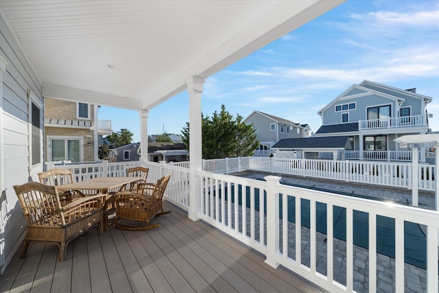 wooden deck with a residential view and outdoor dining space