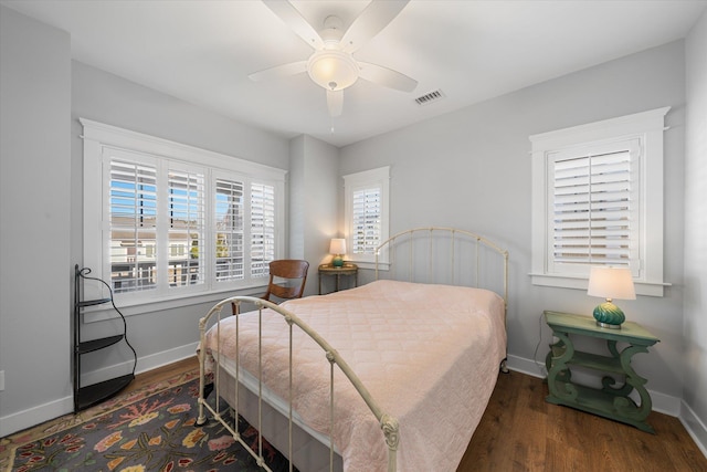 bedroom with ceiling fan, visible vents, baseboards, and dark wood finished floors