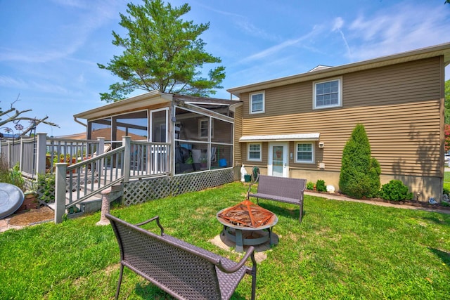 view of front of property with a fire pit, a sunroom, and a front yard