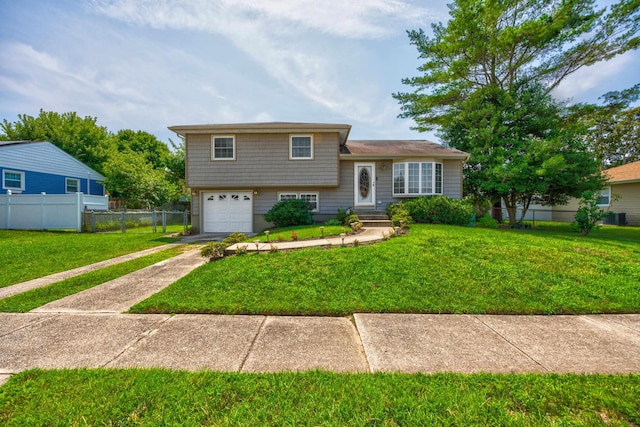 split level home featuring a garage and a front lawn