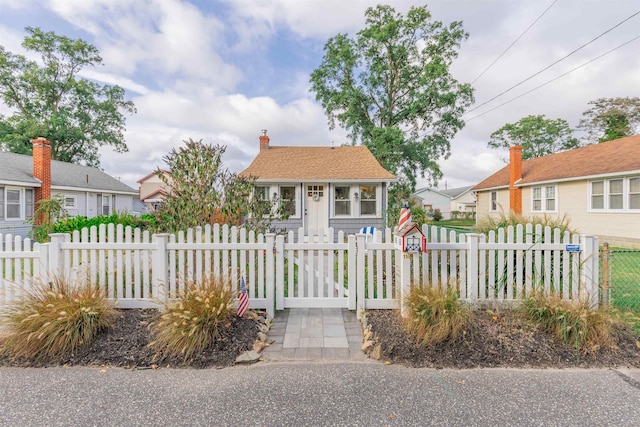 bungalow-style home featuring a fenced front yard, a residential view, a chimney, and a gate