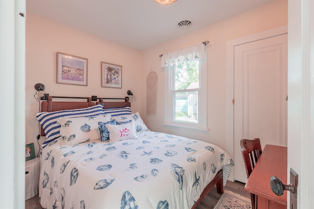 bedroom with visible vents and wood finished floors