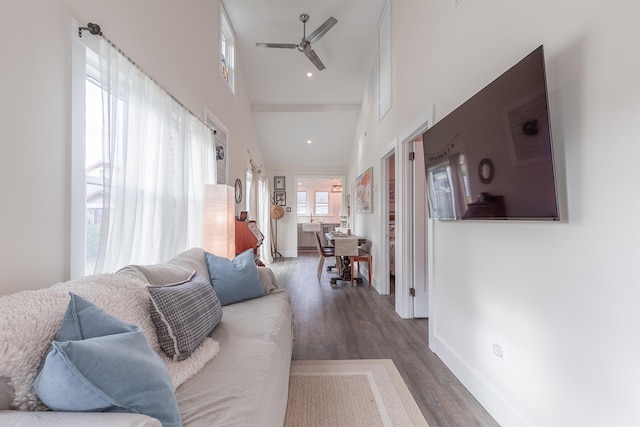 living room featuring wood finished floors, a towering ceiling, recessed lighting, baseboards, and ceiling fan