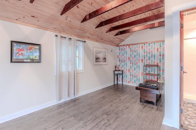 unfurnished room with lofted ceiling with beams, baseboards, wood finished floors, and wooden ceiling