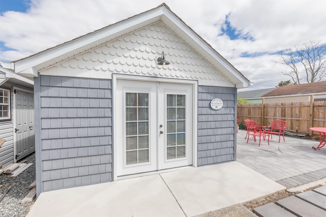 view of outdoor structure featuring french doors, an outdoor structure, and fence