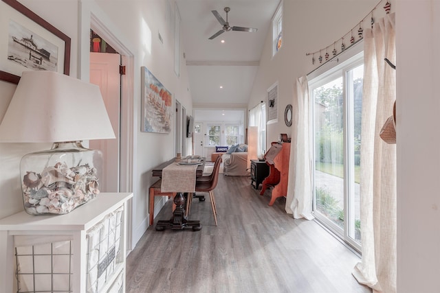 hallway featuring recessed lighting, wood finished floors, and a towering ceiling