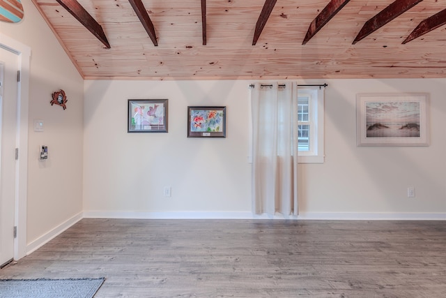 unfurnished room featuring vaulted ceiling with beams, wood ceiling, baseboards, and wood finished floors