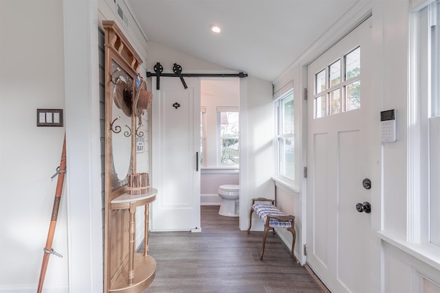 foyer entrance with wood finished floors, baseboards, lofted ceiling, recessed lighting, and a barn door