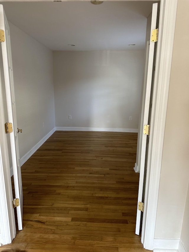 unfurnished room with dark hardwood / wood-style flooring