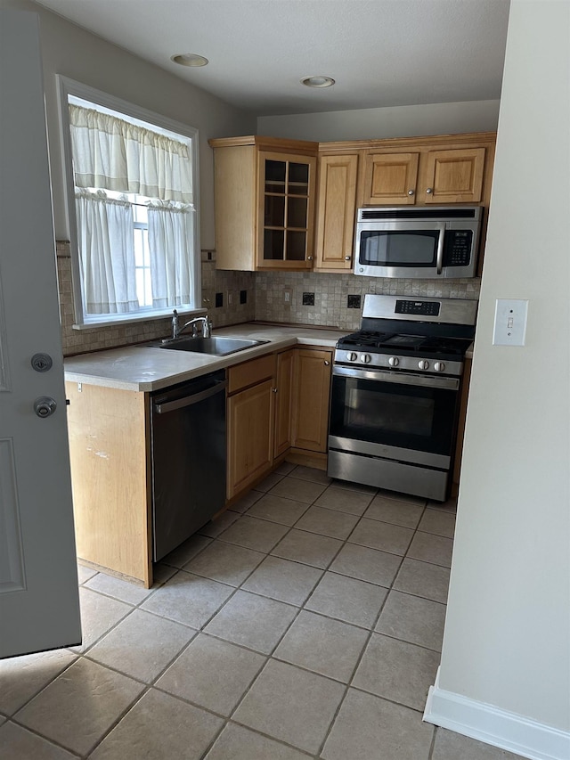 kitchen featuring light tile patterned floors, backsplash, stainless steel appliances, and sink