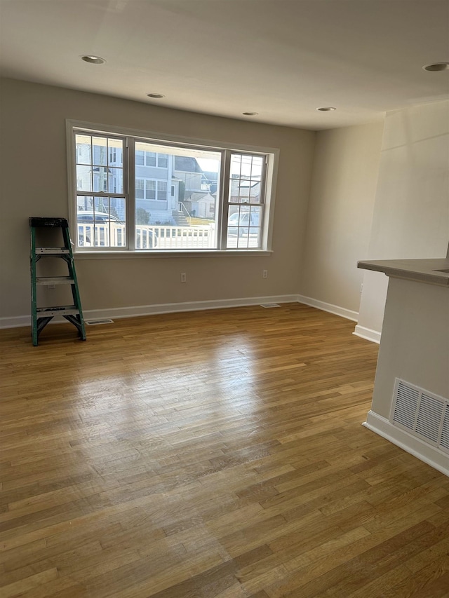 unfurnished room featuring hardwood / wood-style flooring and a healthy amount of sunlight