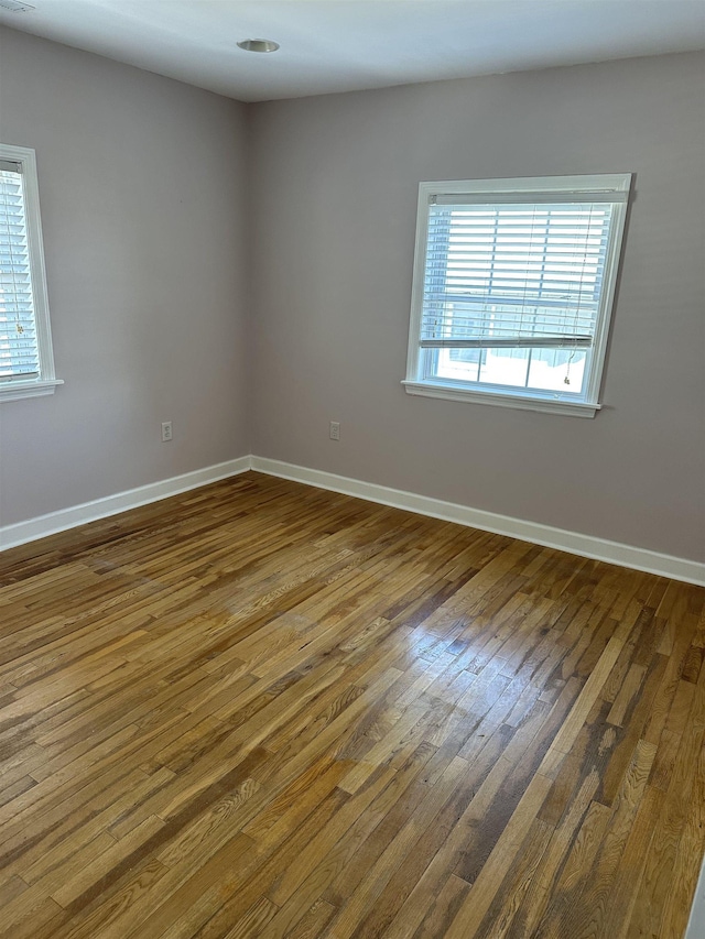 unfurnished room with hardwood / wood-style flooring