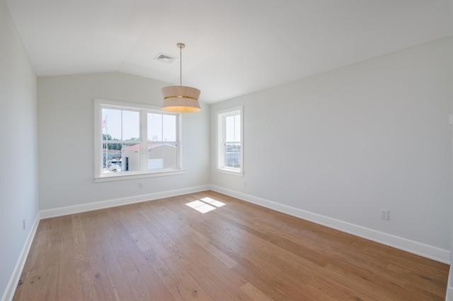 spare room with light hardwood / wood-style floors and vaulted ceiling