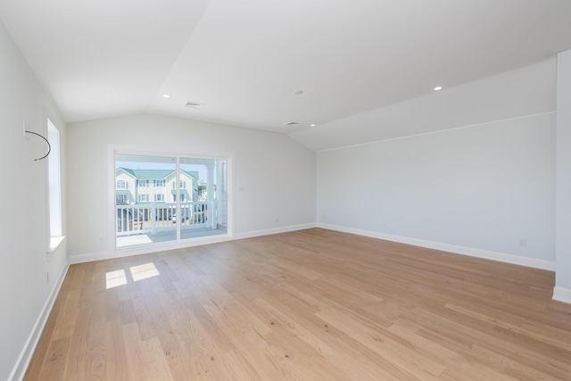 spare room featuring light hardwood / wood-style floors and vaulted ceiling