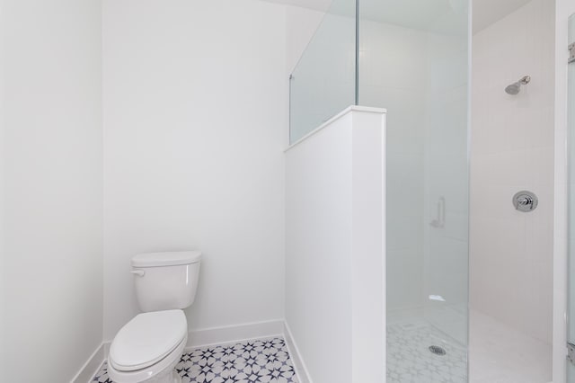 bathroom with tiled shower and toilet