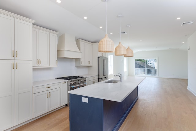 kitchen with white cabinets, pendant lighting, a center island with sink, and custom exhaust hood