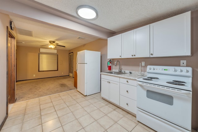 kitchen featuring white appliances, light carpet, white cabinets, sink, and a wall unit AC