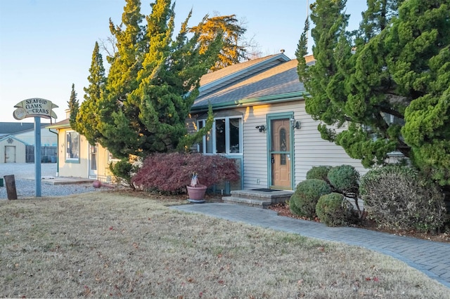 view of front of home featuring an outbuilding and a front lawn