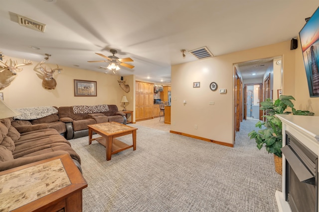 carpeted living room with ceiling fan