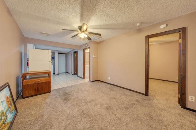 unfurnished living room featuring a textured ceiling, ceiling fan, and light carpet