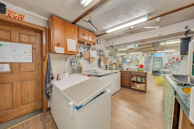 kitchen with a textured ceiling and refrigerator