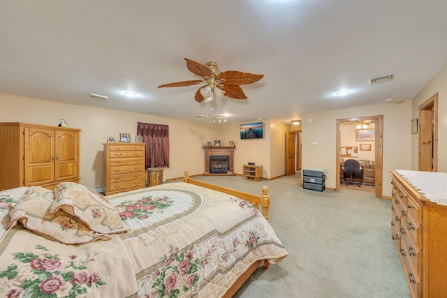 bedroom featuring ceiling fan, light colored carpet, and a baseboard heating unit