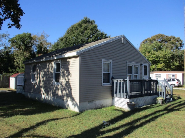 view of property exterior featuring a wooden deck, a yard, and a shed