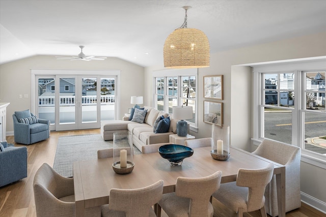 dining room featuring ceiling fan, vaulted ceiling, and light wood-style floors
