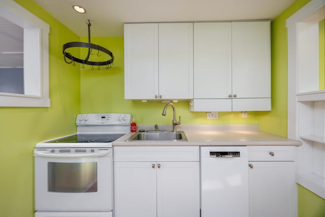 kitchen featuring sink, white cabinets, and white appliances