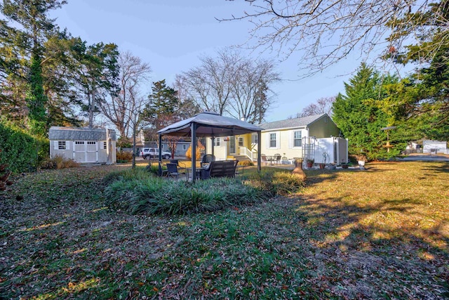 rear view of property with a gazebo, a yard, and a shed