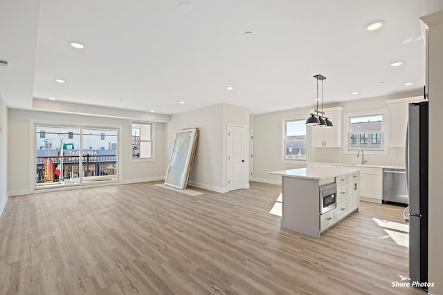 3130 Pacific Ave Unit 3130, Wildwood, NJ 08260 - kitchen featuring appliances with stainless steel finishes, a kitchen island, white cabinets, light wood-style flooring, and light countertops