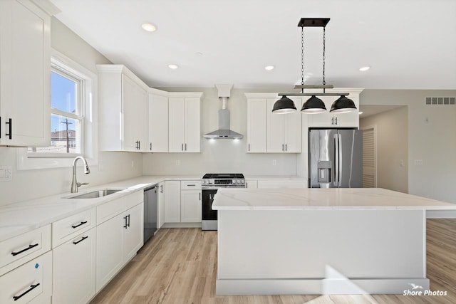 3130 Pacific Ave Unit 3130, Wildwood, NJ 08260 - kitchen featuring appliances with stainless steel finishes, wall chimney exhaust hood, a sink, a center island, and light stone countertops