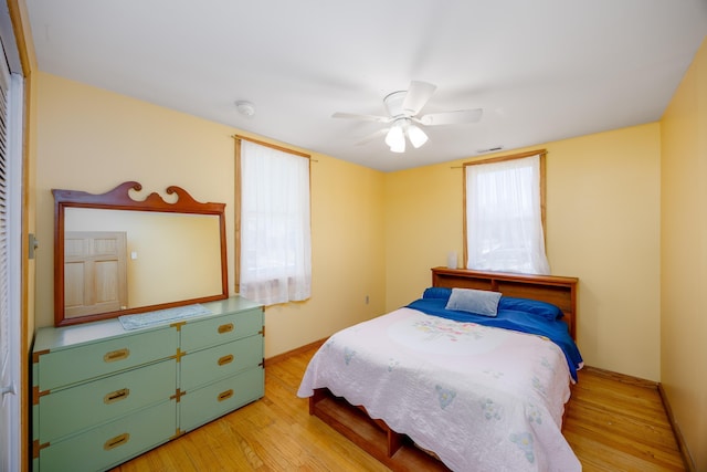 bedroom featuring wood finished floors, visible vents, and ceiling fan