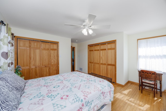 bedroom with light wood-type flooring, visible vents, multiple closets, baseboards, and ceiling fan