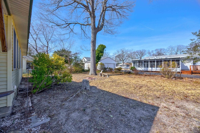 view of yard featuring fence and a sunroom