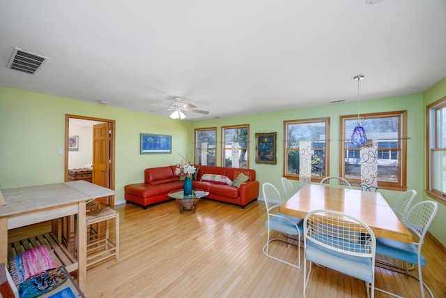 dining space featuring a ceiling fan, visible vents, light wood finished floors, and baseboards