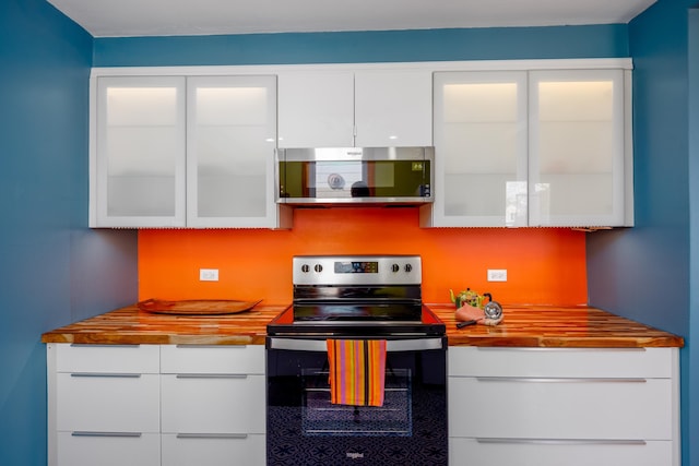 kitchen with butcher block countertops, white cabinets, appliances with stainless steel finishes, and modern cabinets