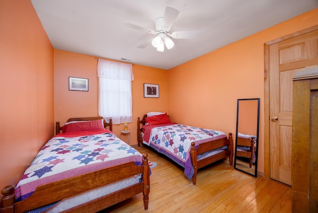 bedroom featuring visible vents, light wood-style floors, and a ceiling fan