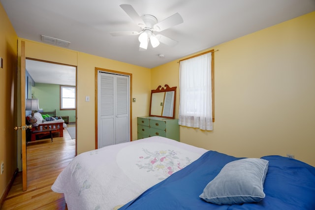 bedroom with a closet, visible vents, ceiling fan, and light wood-style floors