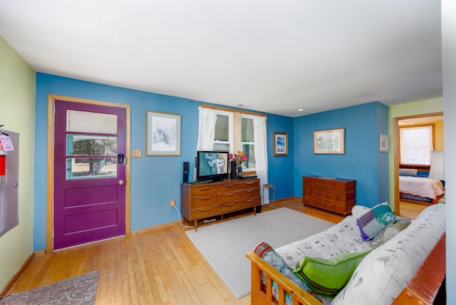 interior space with baseboards, wood-type flooring, and multiple windows