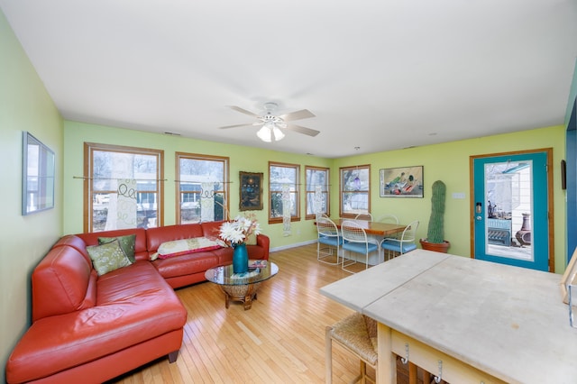 living area featuring visible vents, baseboards, wood-type flooring, and ceiling fan