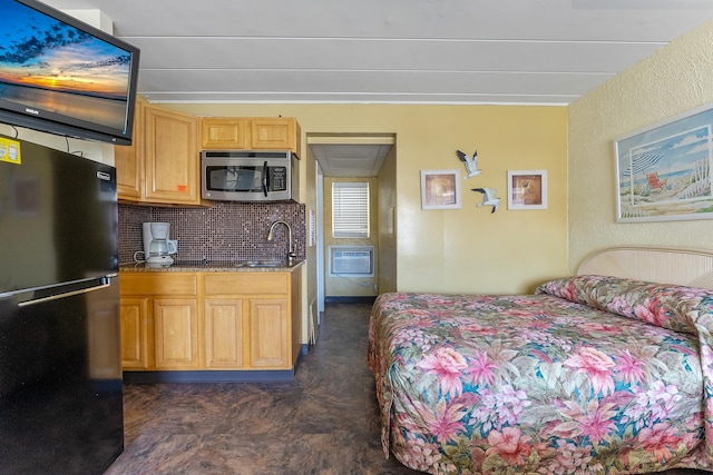 bedroom with black fridge, an AC wall unit, and sink