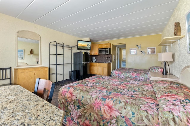 bedroom featuring black fridge