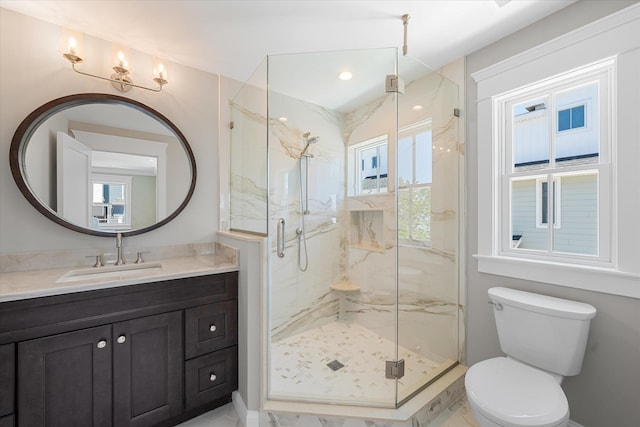 bathroom with toilet, a marble finish shower, and vanity