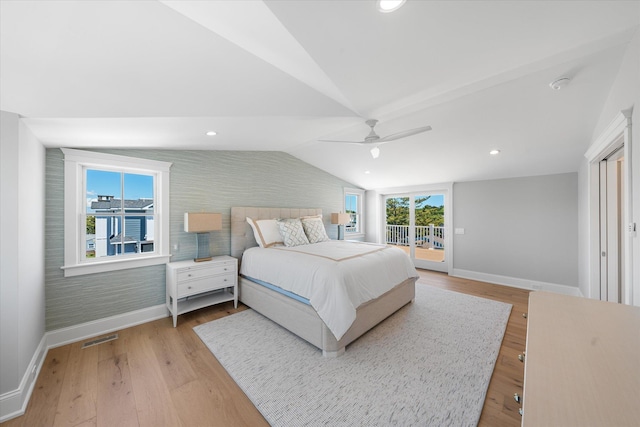 bedroom with baseboards, visible vents, lofted ceiling, wood finished floors, and access to outside