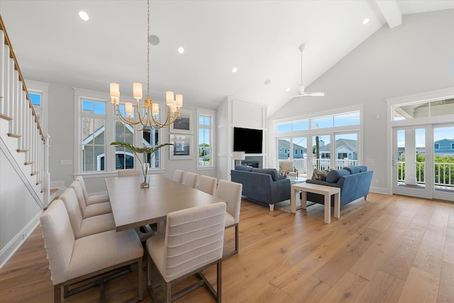 dining area featuring beam ceiling, stairway, light wood-style floors, high vaulted ceiling, and baseboards