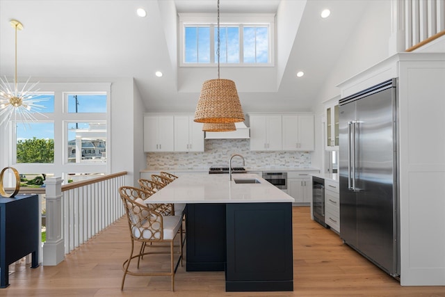 kitchen featuring light wood finished floors, light countertops, appliances with stainless steel finishes, and wine cooler